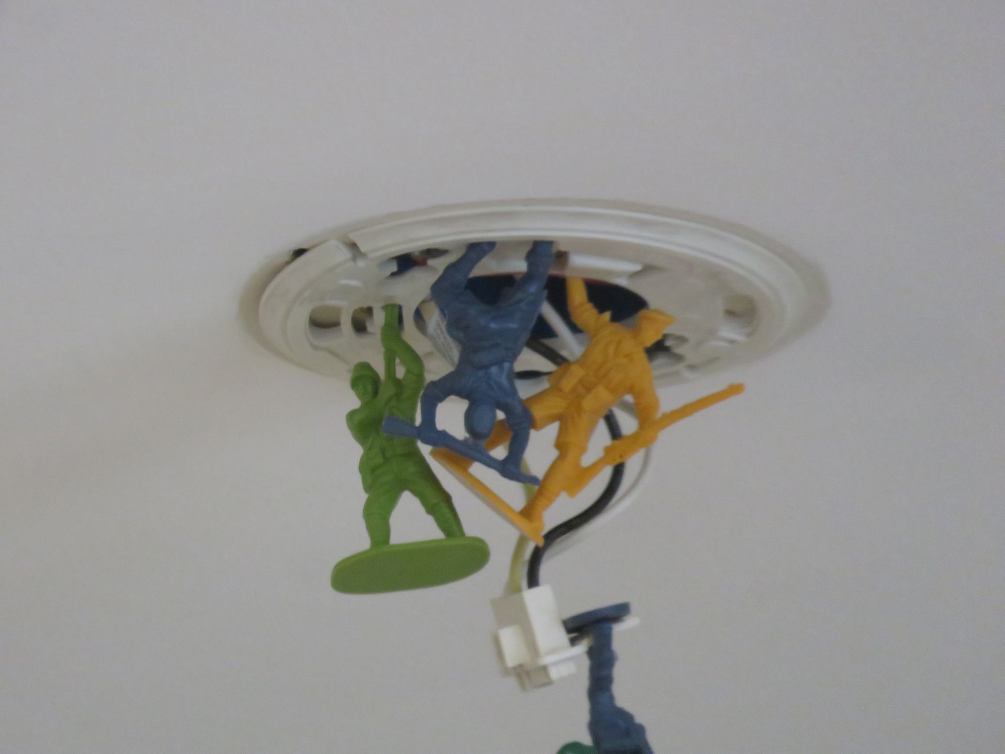 Toy soldiers hanging off of a ceiling fixture